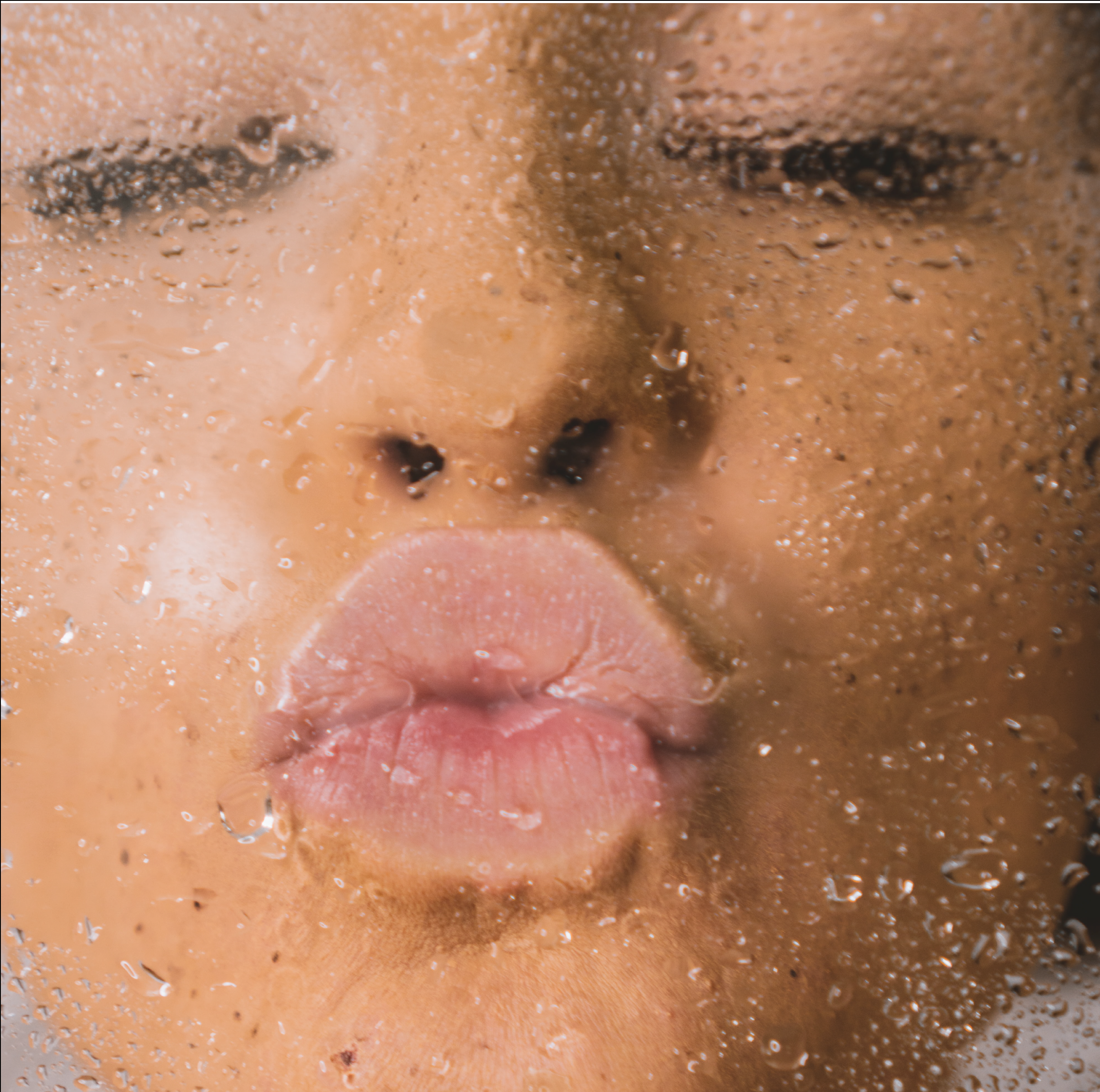 Woman kissing glass with water droplets