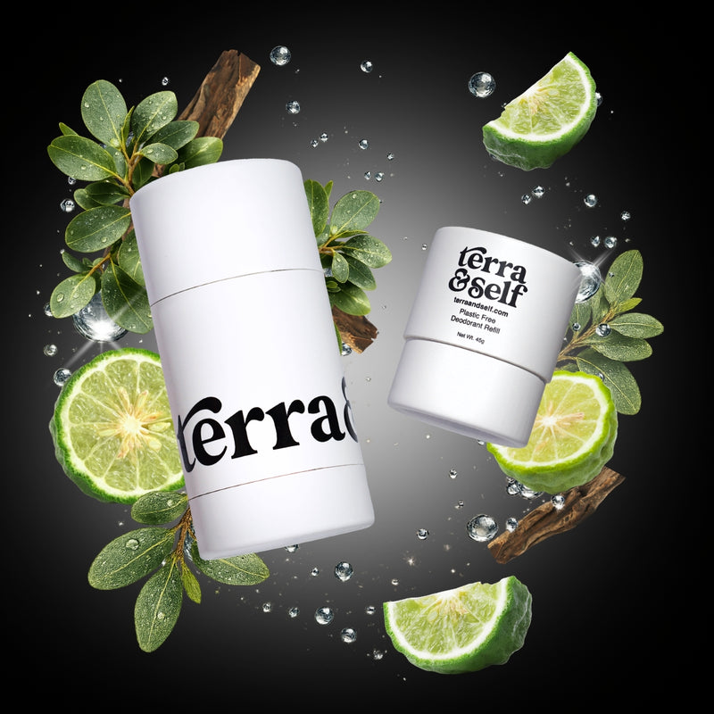 Terra & Self reusable deodorant applicator and plastic-free refill displayed against a dark background, surrounded by fresh lime slices, green leafy branches, wood bark, and scattered water droplets.