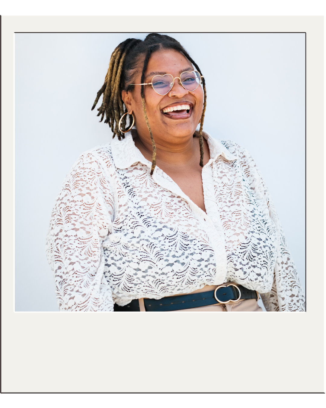 Founder of Terra and Self laughing in a white lace top and heart-shaped sunglasses, polaroid-style portrait