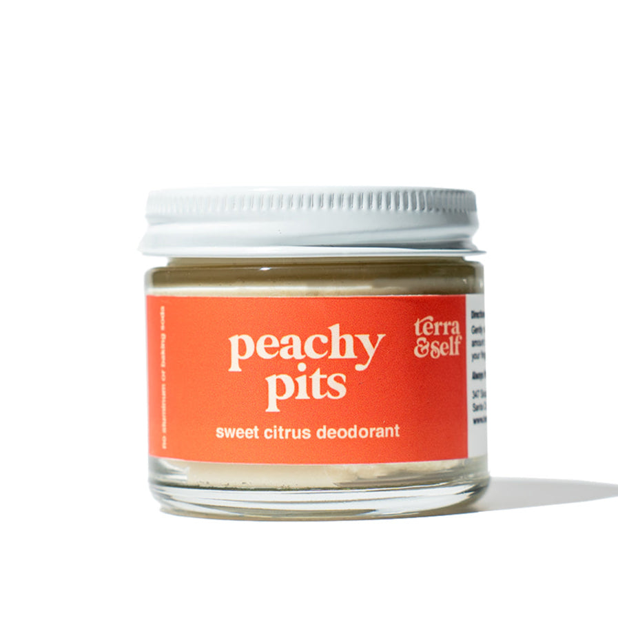 A glass jar with a white lid containing solid deodorant, labeled &