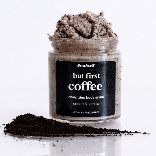 But First Coffee Body Scrub by Terra and Self shown with coffee in front.